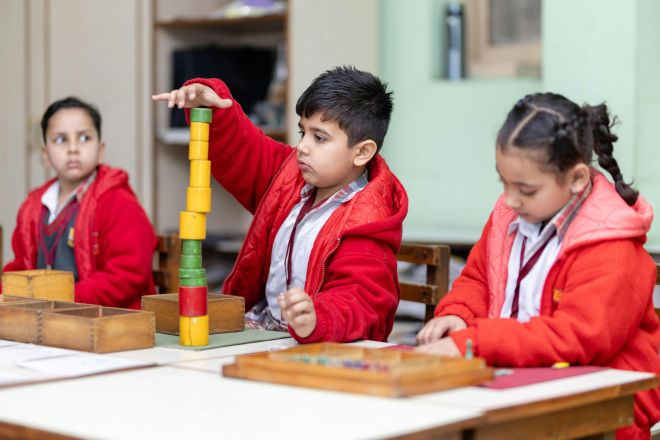 Children learning with Montessori materials in a classroom setting, fostering creativity and focus.
